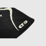 Close-up of the Hellstar Warm Up Shorts 'Black,' showcasing a stylized Hellstar design with white abstract graphics and symbols. A star and crescent moon-like shape can be seen on the lower right corner.